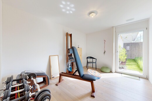 gym avec natural light, lumière naturelle, wood finish floor, sol en finition bois, et drywall