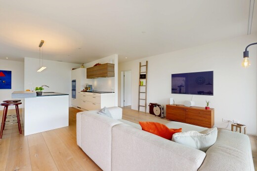 salon avec wood finish floor, sol en finition bois, inside property, full kitchen, et drywall