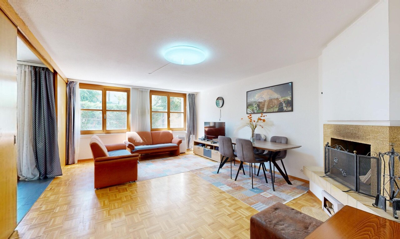 wohn- / esszimmer mit drywall, gipskartonwand, parquet floor, fernseher, und wood finish floor