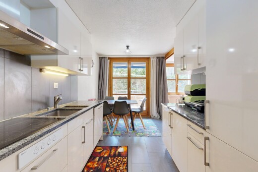 kitchen featuring exhaust hood, dark stone counters, and white cabinets