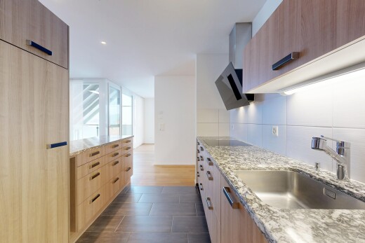 küche mit stein arbeitsplatten, schränke mit flachen paneelen, hellbraune schränke, inside property, und natural light