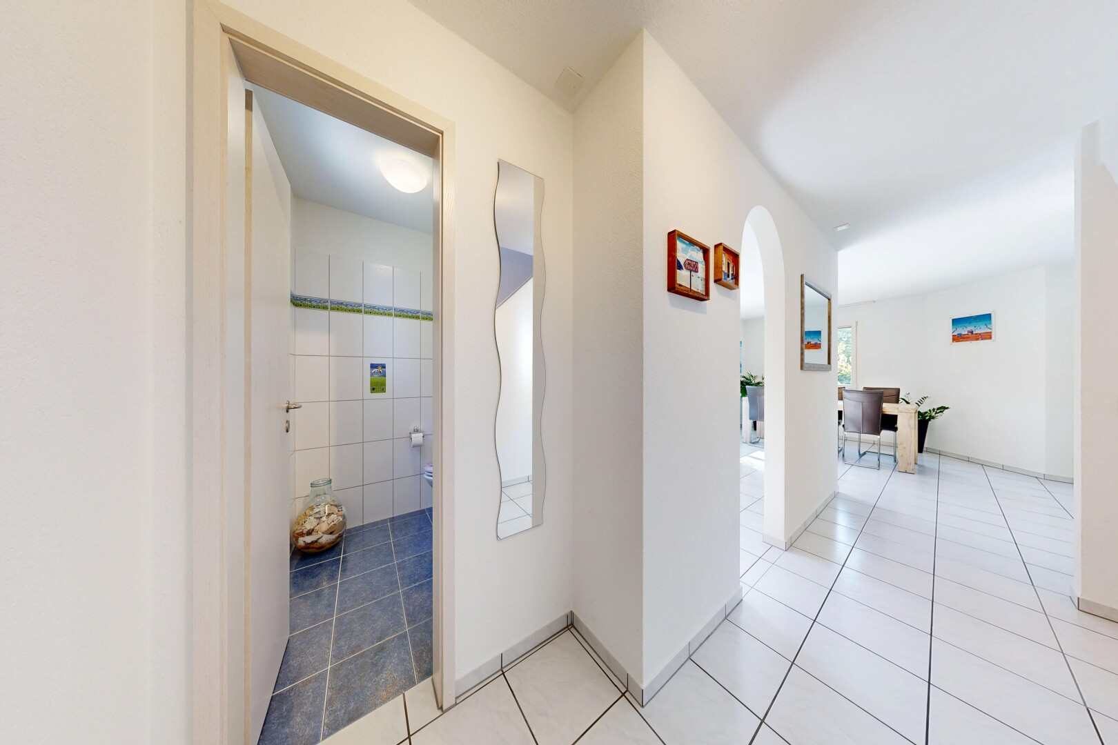 halle / korridor mit gewölbte gehwege, gipskartonwand, drywall, fliesenboden, und tile floor