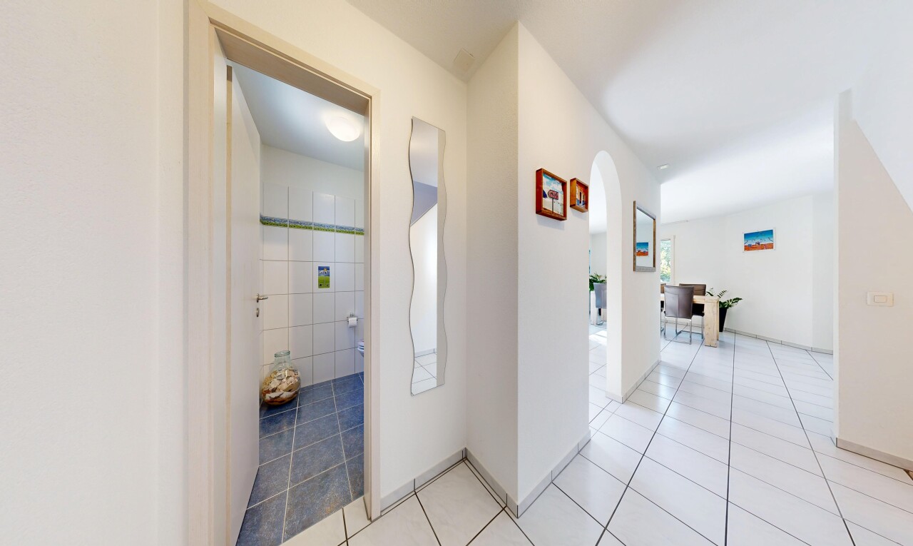 halle / korridor mit gewölbte gehwege, gipskartonwand, drywall, fliesenboden, und tile floor
