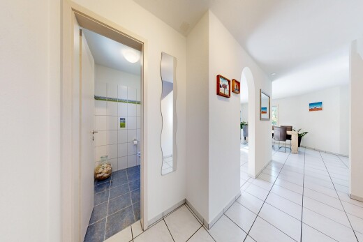 halle / korridor mit gewölbte gehwege, gipskartonwand, drywall, fliesenboden, und tile floor