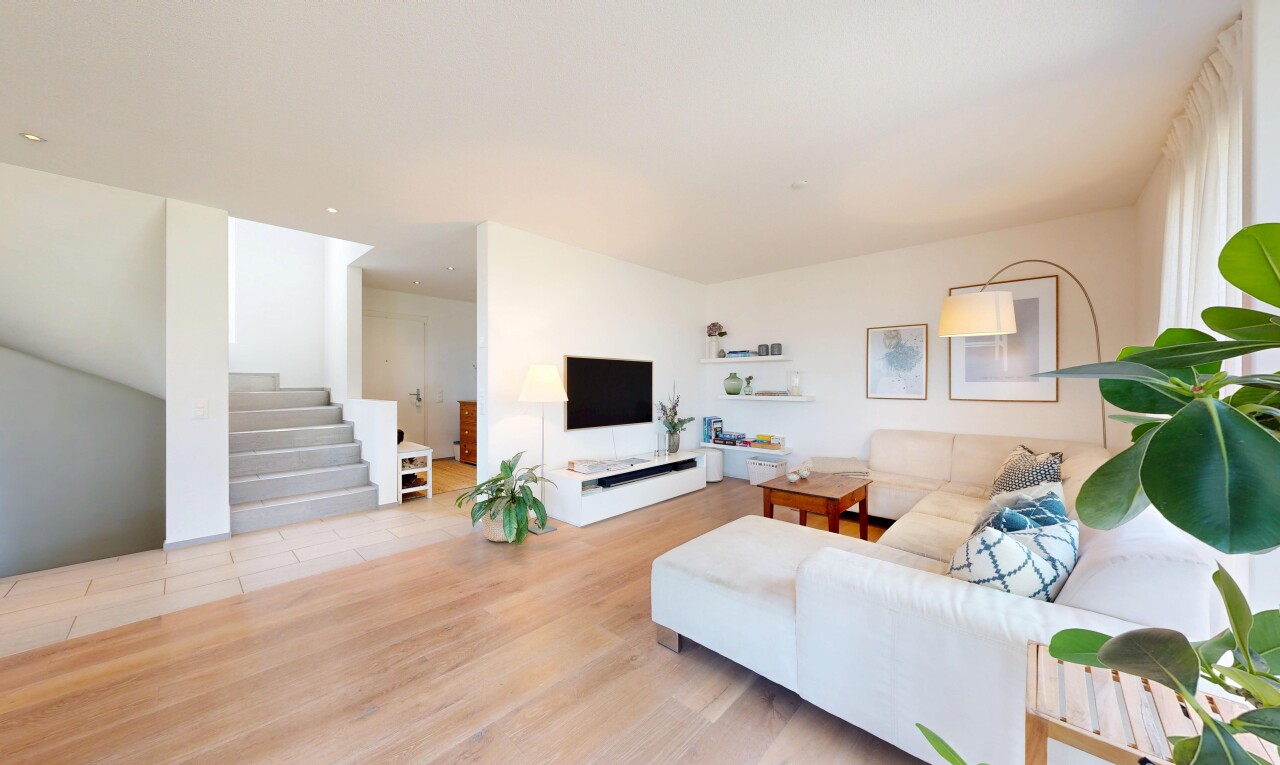 wohnzimmer mit treppen, fernseher, drywall, gipskartonwand, und wood finish floor