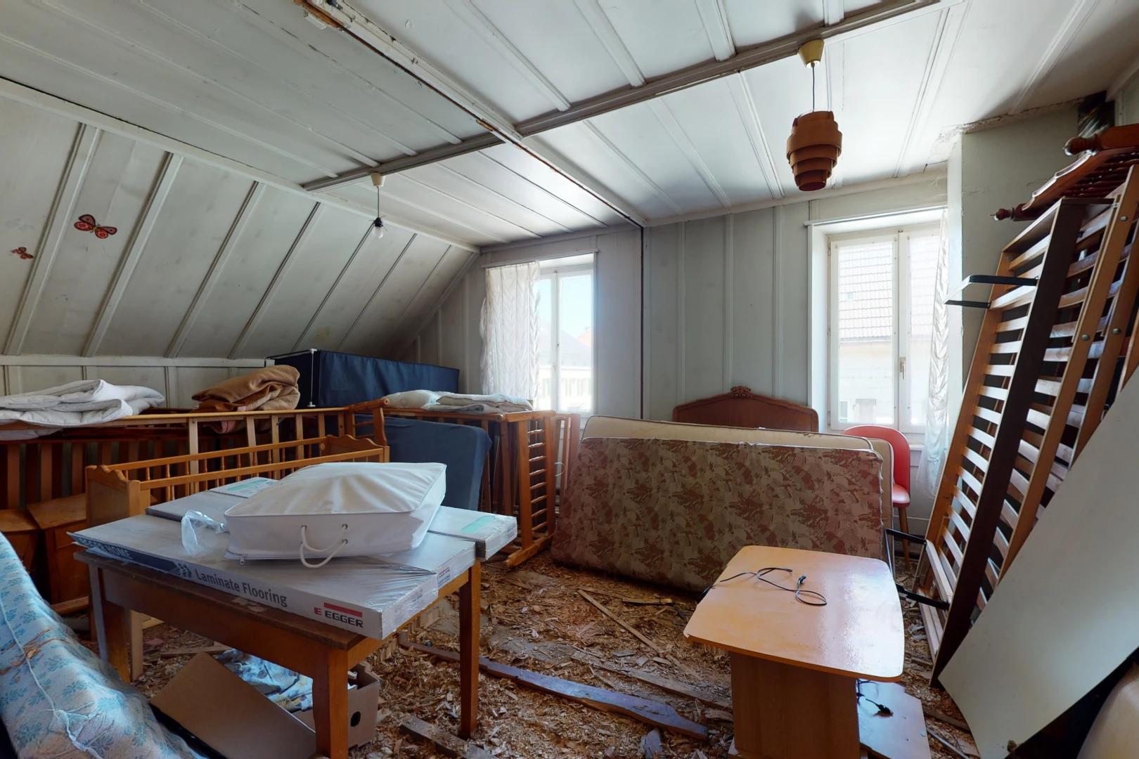 schlafzimmer mit haftdecke mit balken und mehreren fenstern