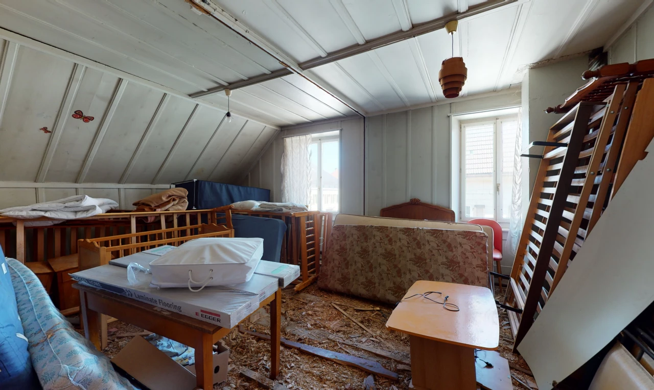 schlafzimmer mit haftdecke mit balken und mehreren fenstern