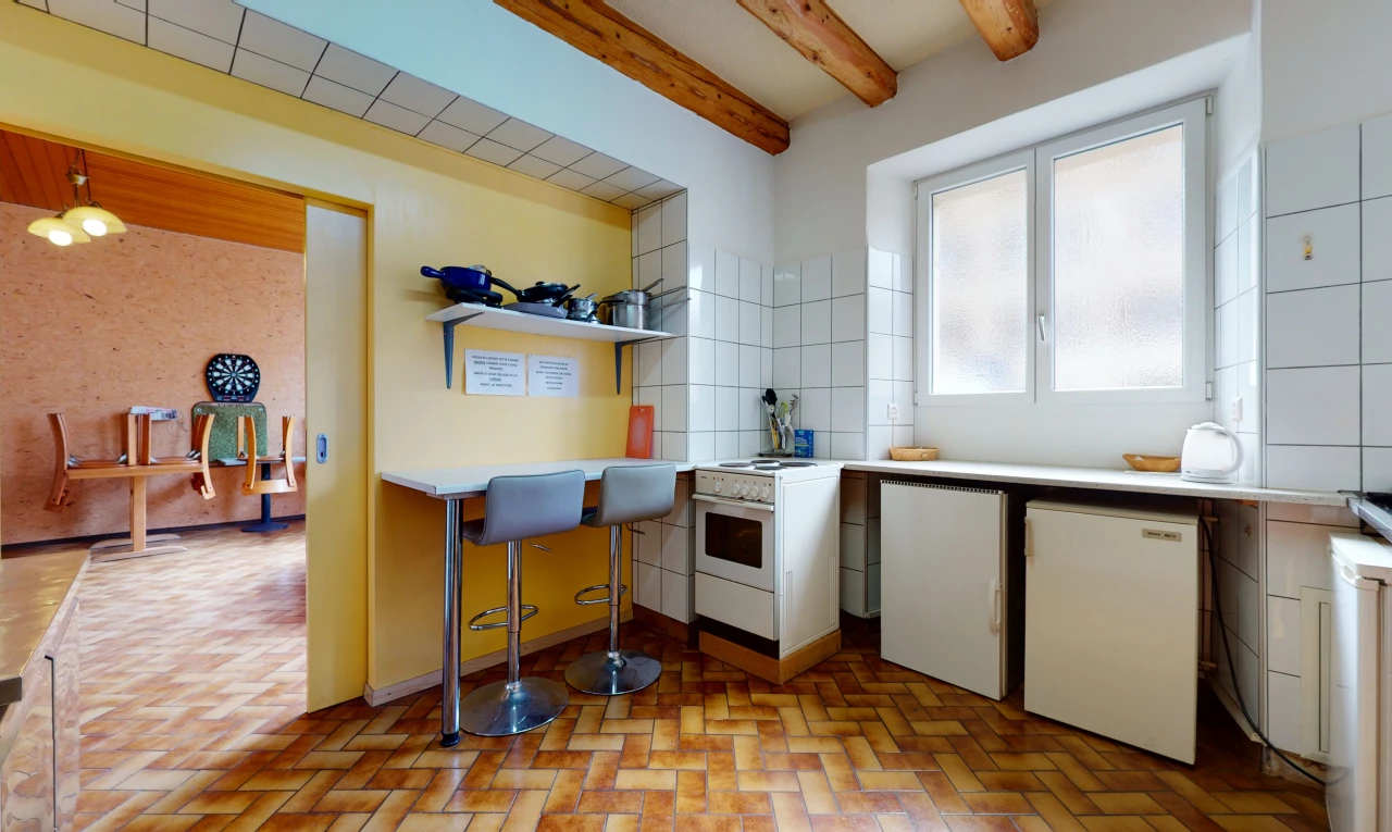 küche mit holzstrahldecke, hellen fliesenböden und hellen arbeitsplatten