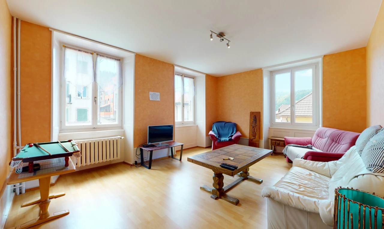 wohnzimmer mit einer fülle von natürlichen licht, holzböden, fernseher und kühler