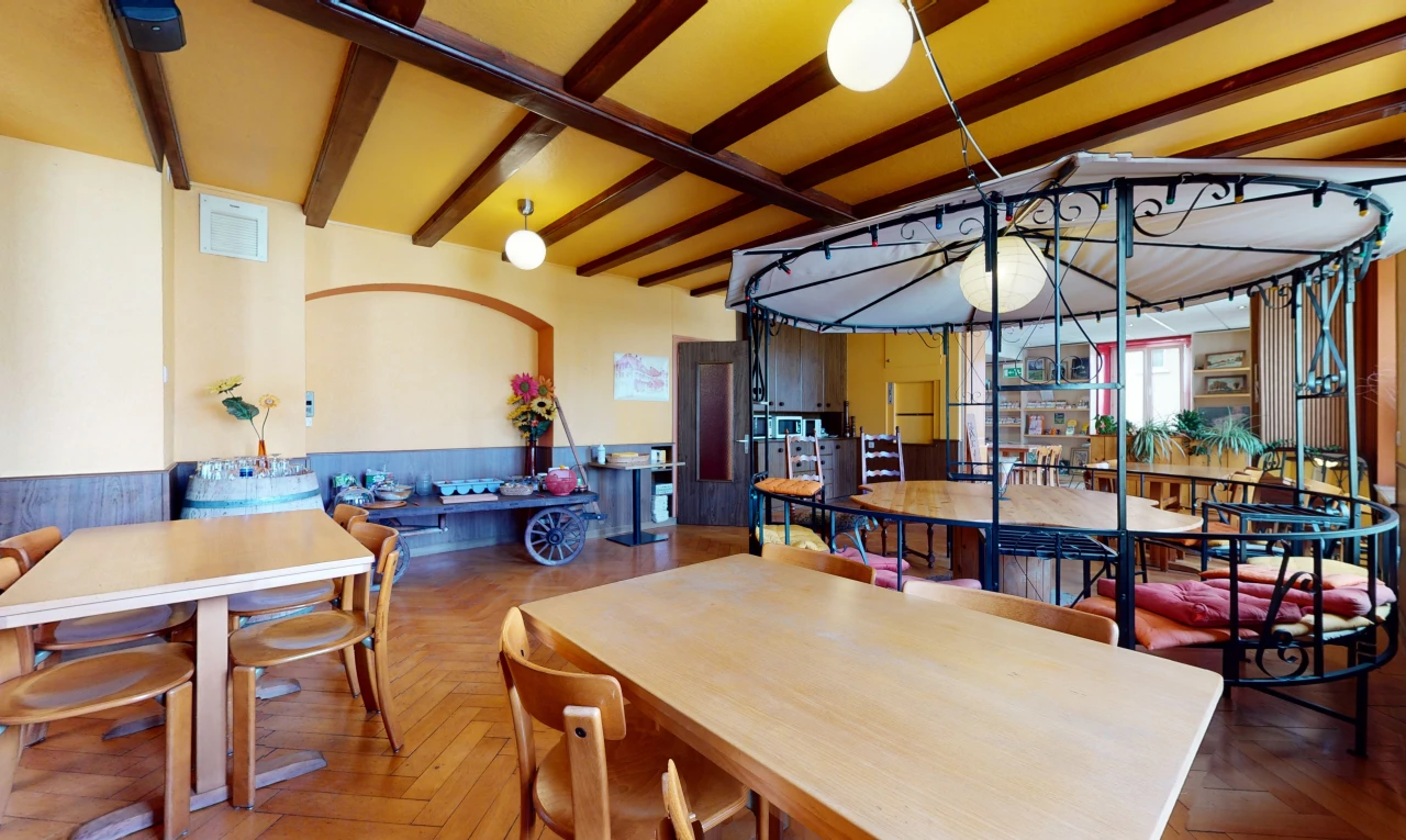 hartholzboden -esszimmer mit natürlicher licht, balkendecke und einer küchenfrühstücksbar
