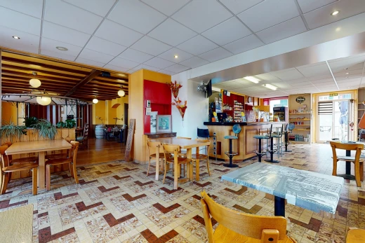 tiled living room featuring a kitchen breakfast bar and natural light