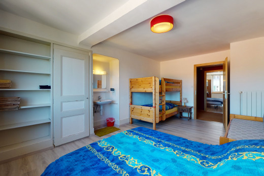 chambre à coucher avec parquet et poutres apparentes
