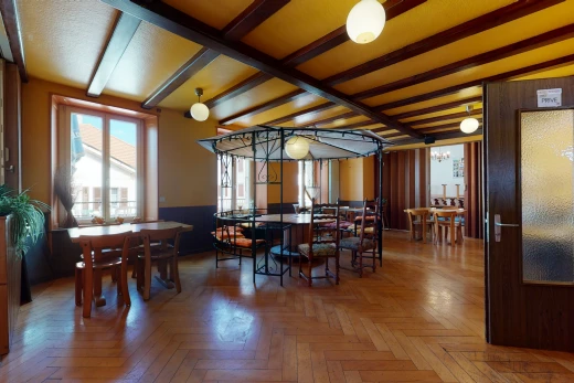 dining space featuring natural light, beamed ceiling, and hardwood floors