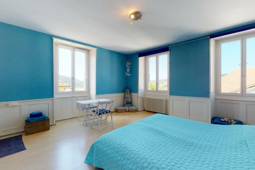 hardwood floored bedroom featuring multiple windows and radiator
