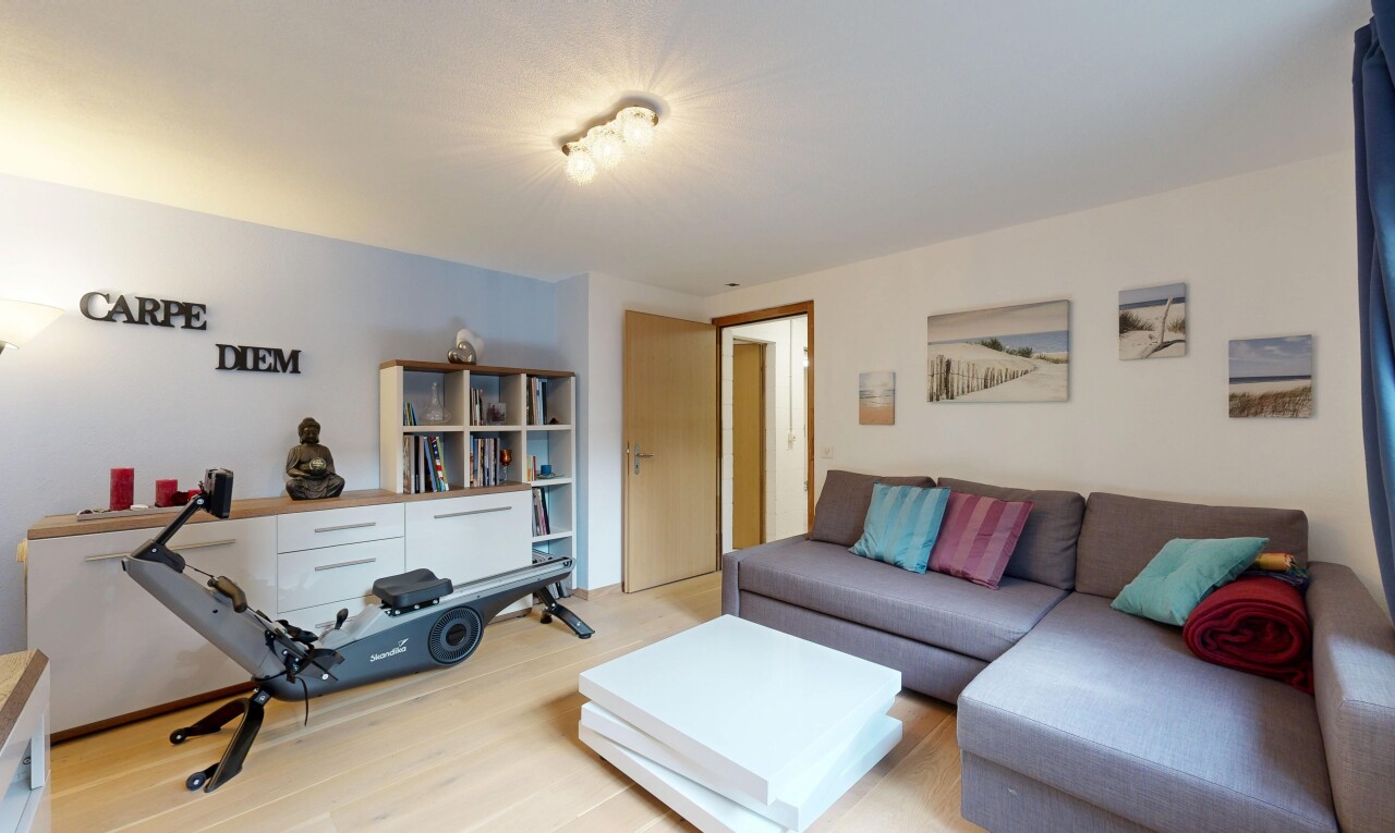 salon avec cloison sèche, drywall, inside property, sol en finition bois, et wood finish floor
