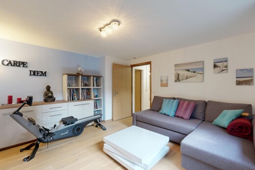 salon avec cloison sèche, drywall, inside property, sol en finition bois, et wood finish floor