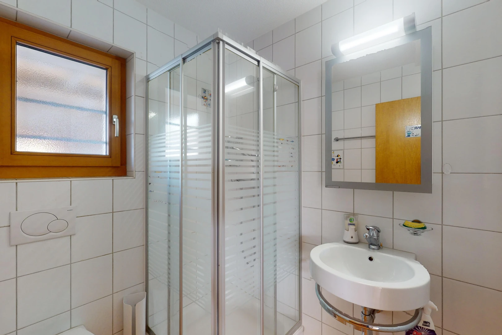 bathroom featuring tasteful backsplash, tile walls, sink, and an enclosed shower