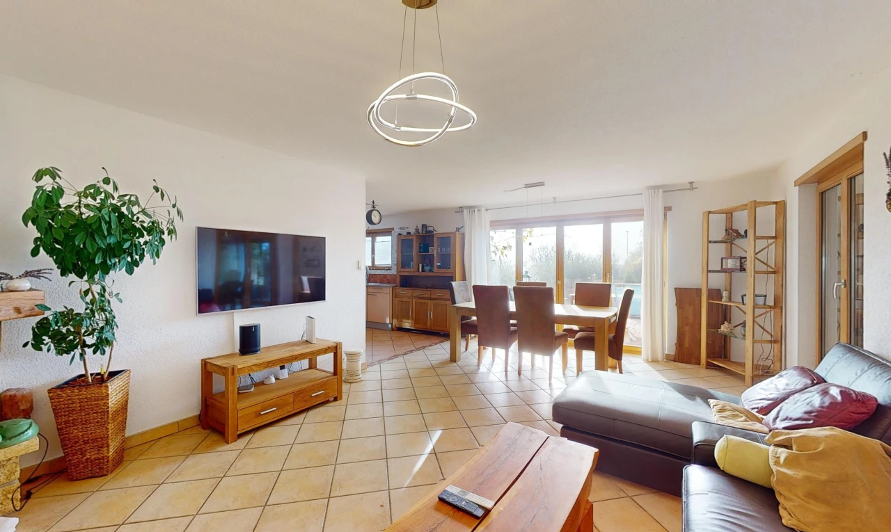 tiled living / dining room with an inviting chandelier