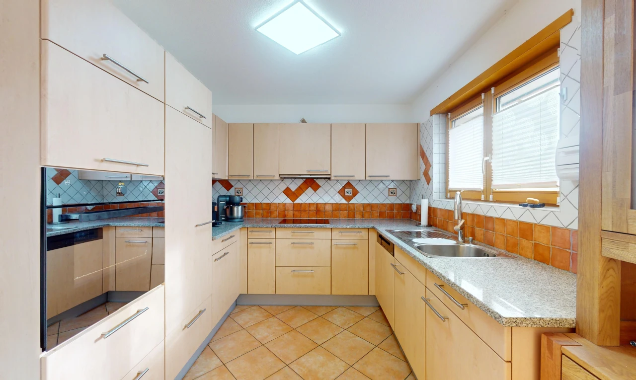 kitchen featuring sink, light brown cabinets, backsplash, and light tile patterned floors