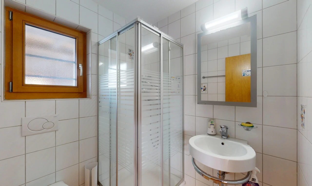 bathroom featuring tasteful backsplash, tile walls, sink, and an enclosed shower