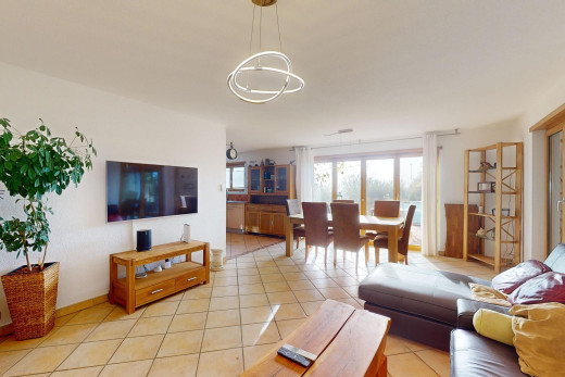 salon / salle à manger avec carrelage, lustre, télévision, et lumière naturelle