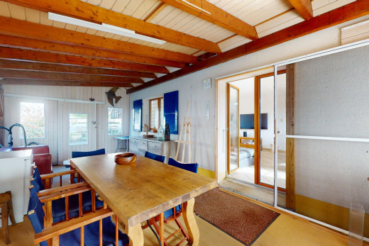 salle à manger avec poutres apparentes, lumière naturelle, et plafond voûté