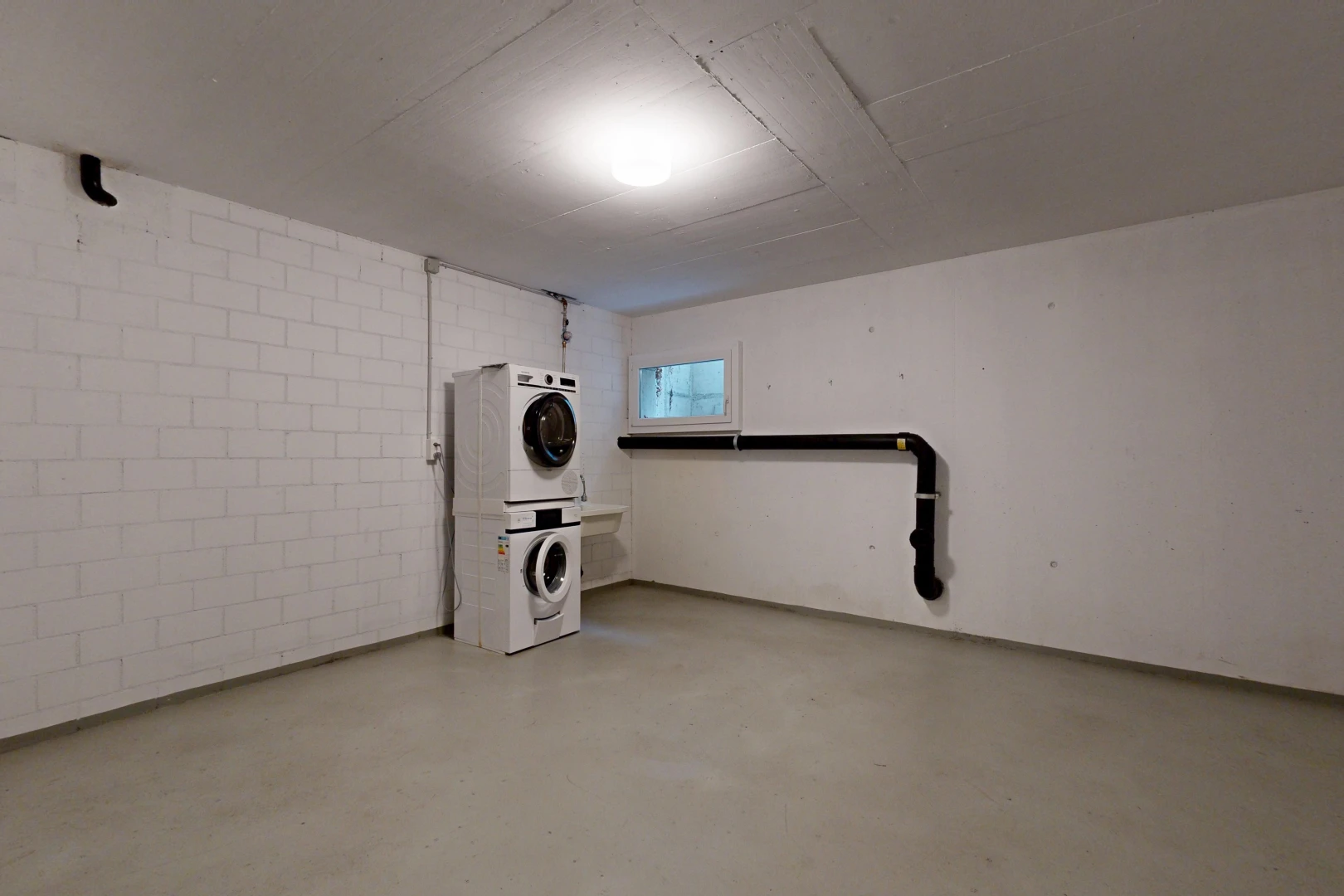 wäschekammer mit waschturm, natürliches licht, betonboden, concrete floor, und betonblockwand