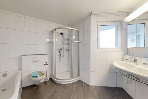 bathroom with tile walls and a shower stall