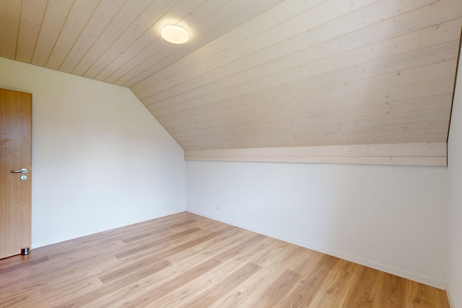 leerer raum mit zusätzliches zimmer, holzfußboden, wood finish floor, dachschräge, und vaulted ceiling