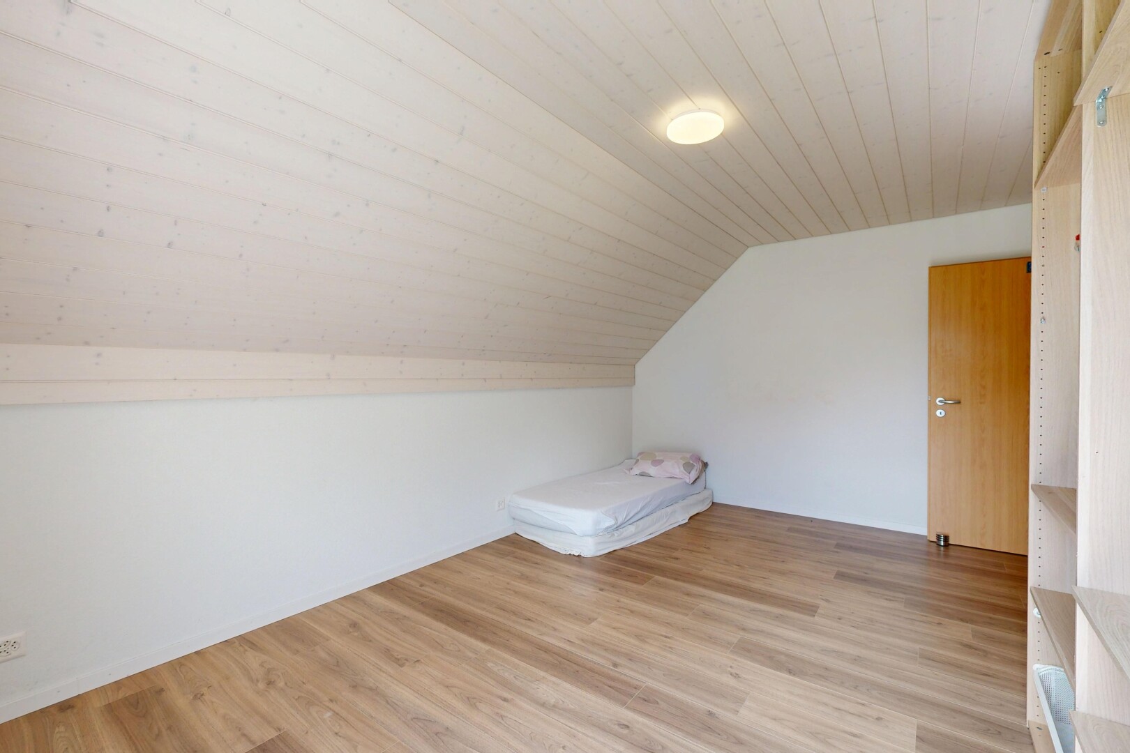 leerer raum mit zusätzliches zimmer, dachschräge, vaulted ceiling, holzfußboden, und wood finish floor