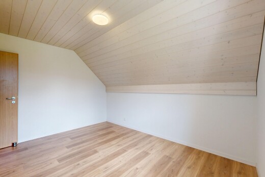 pièce vide avec pièce supplémentaire, sol en finition bois, wood finish floor, plafond voûté, et vaulted ceiling