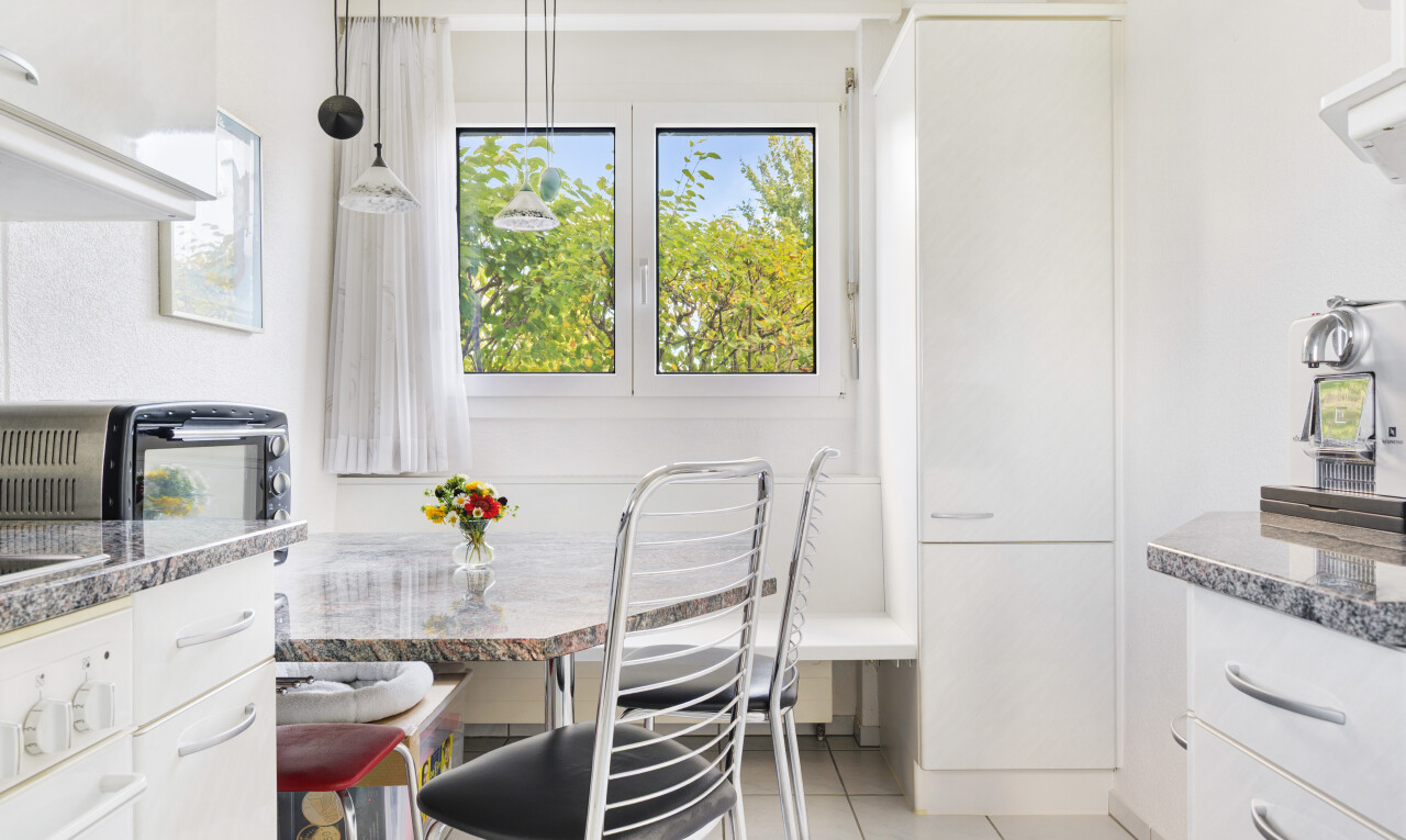 küche mit weiße schränke, stein arbeitsplatten, natürliches licht, natural light, und pendelleuchte