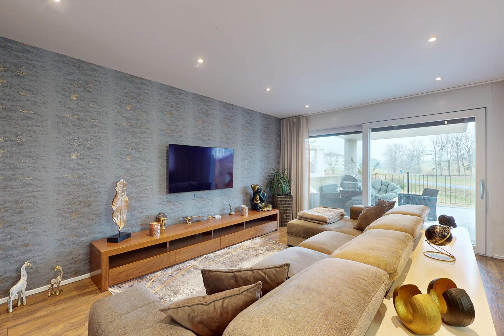 salon avec lumière naturelle, télévision, et plancher de bois