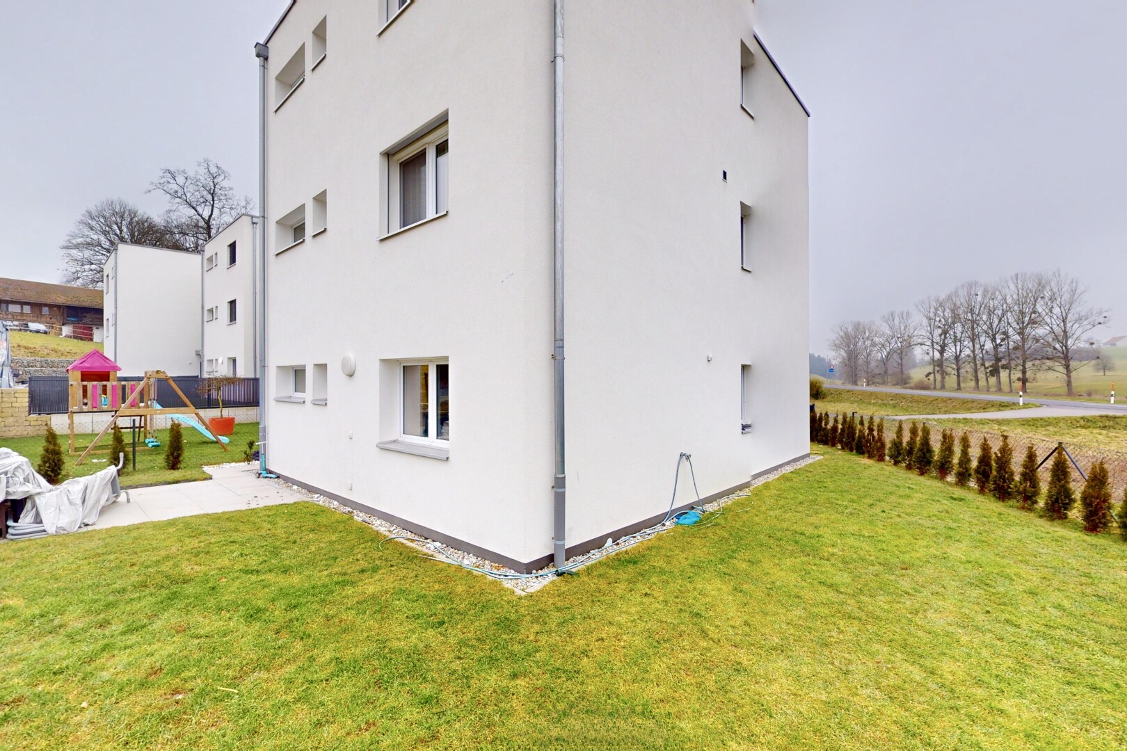 façade avec terrain de jeux et pelouse