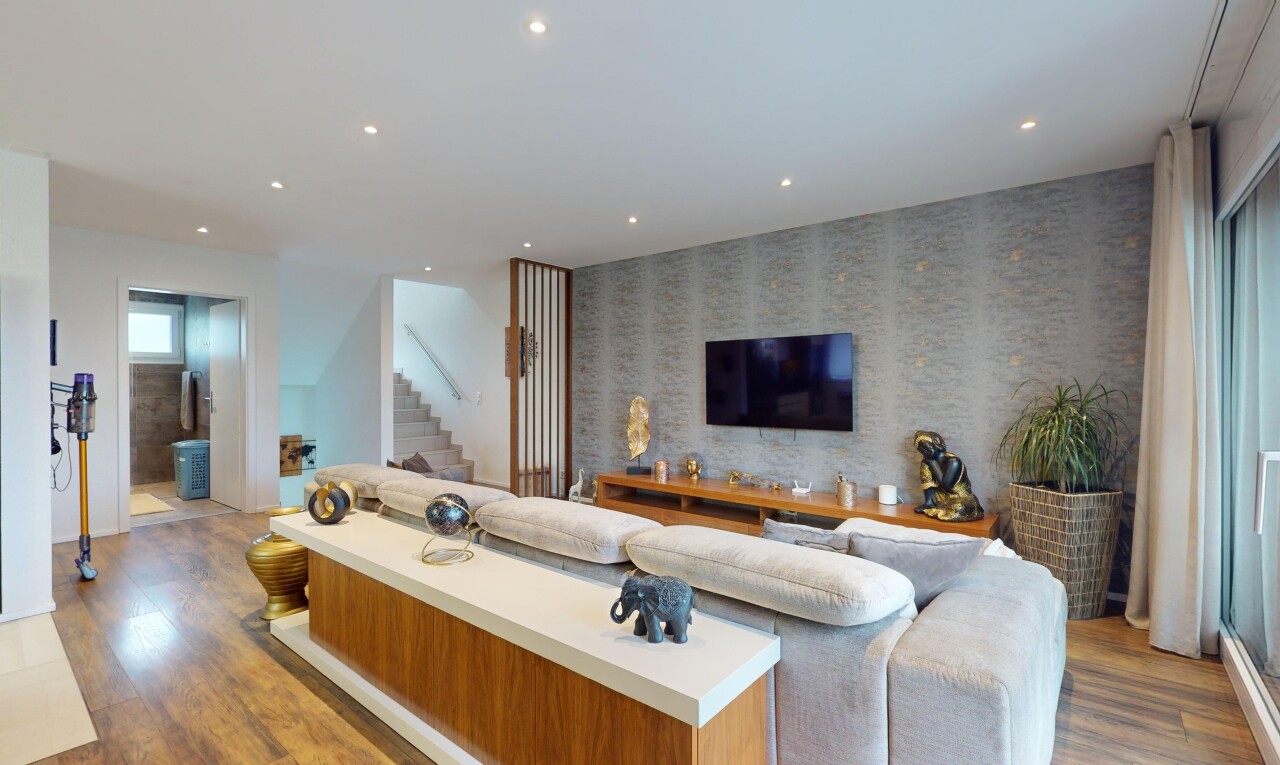 salon avec lumière naturelle, plancher de bois, et télévision