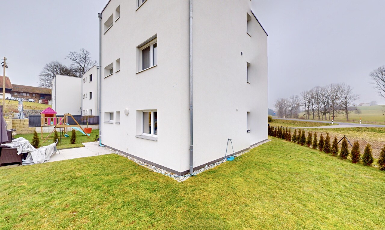 façade avec terrain de jeux et pelouse