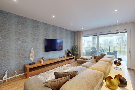 salon avec lumière naturelle, télévision, et plancher de bois