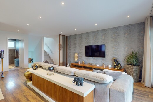 salon avec lumière naturelle, plancher de bois, et télévision