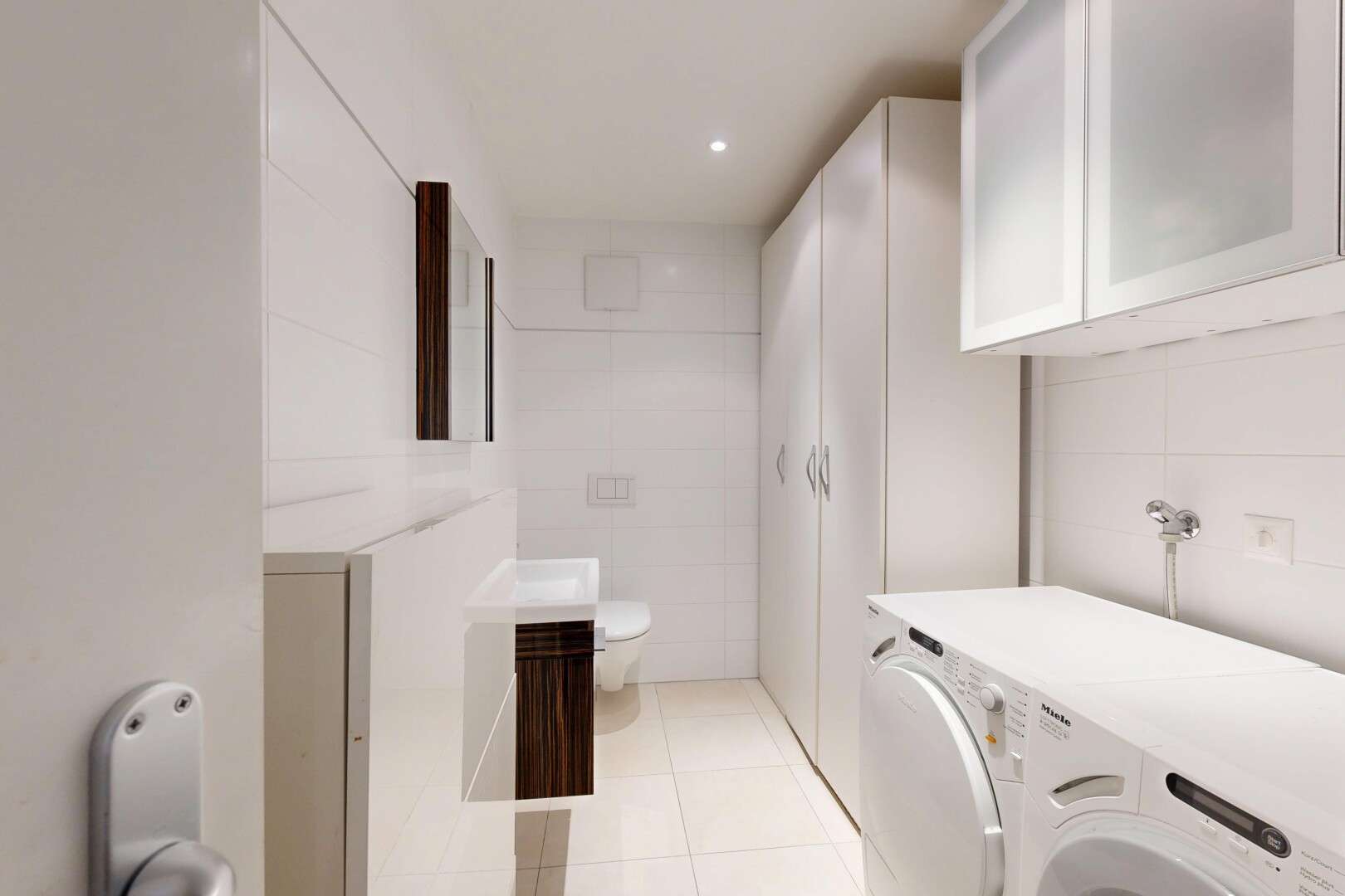 buanderie avec light floor, sol en carrelage, tile floor, inside property, et mur en carrelage