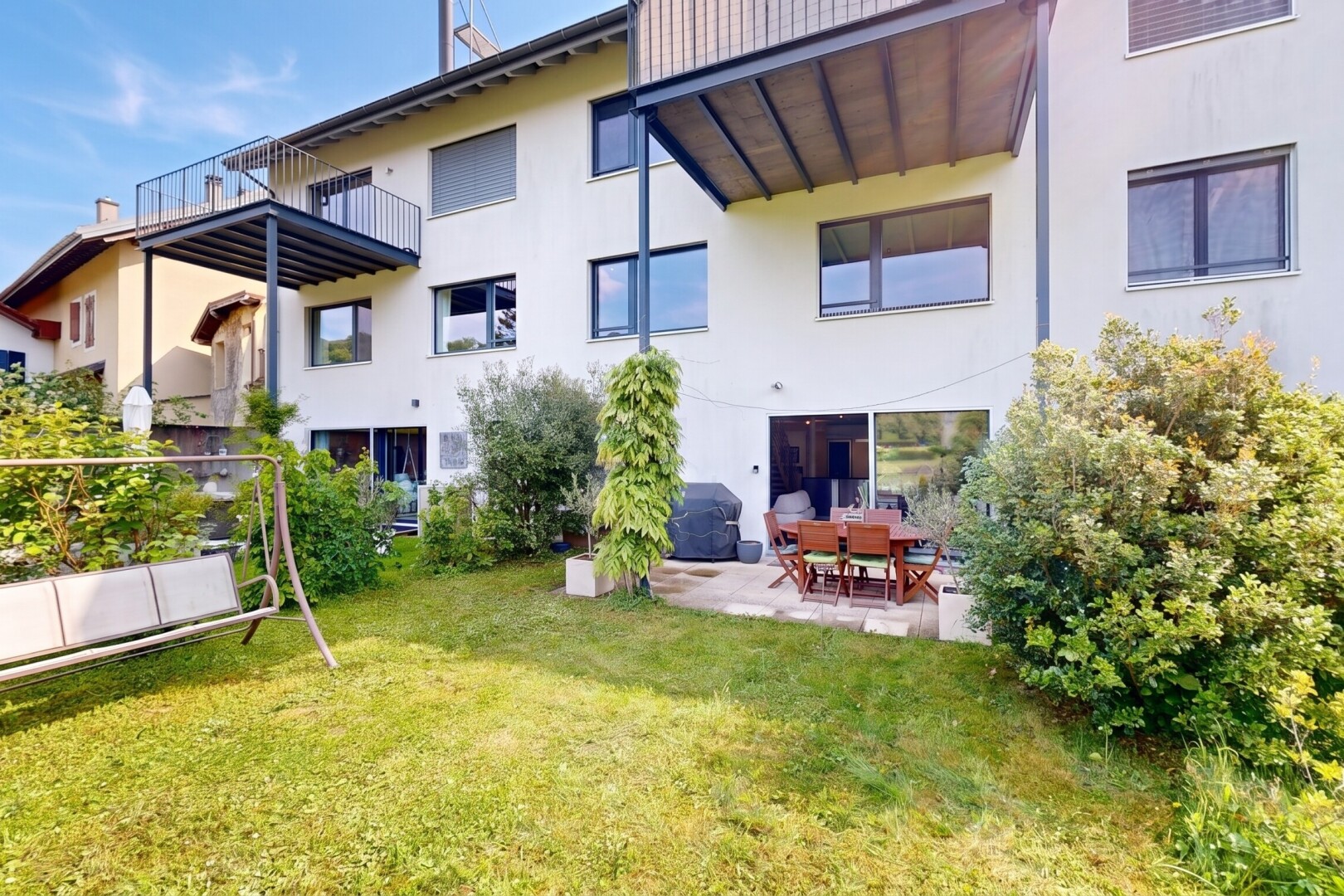 façade avec pelouse, day time, bardage en stuc, terrasse, et property visible