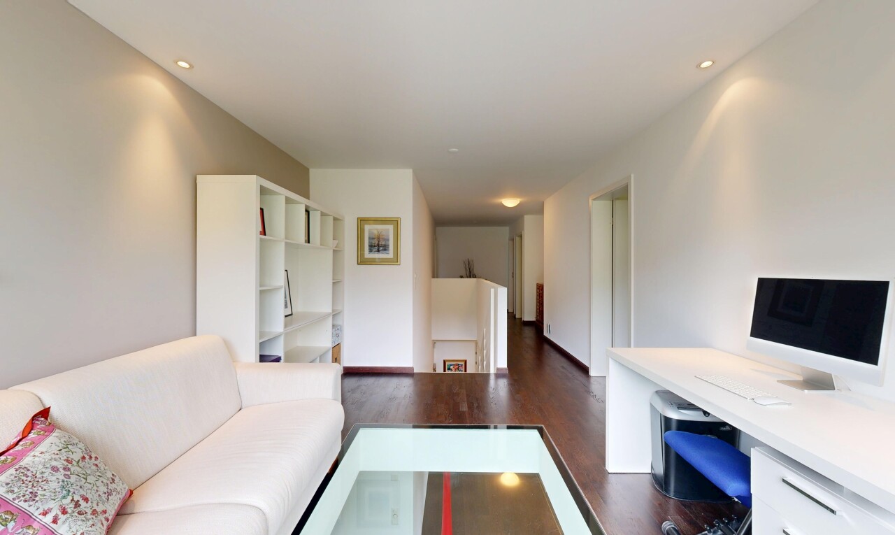 salon avec inside property, télévision, cloison sèche, drywall, et sol en finition bois