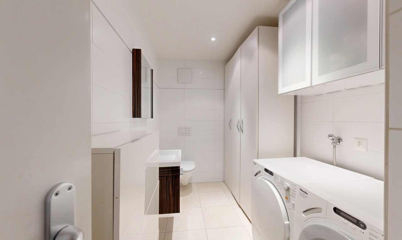 buanderie avec light floor, sol en carrelage, tile floor, inside property, et mur en carrelage