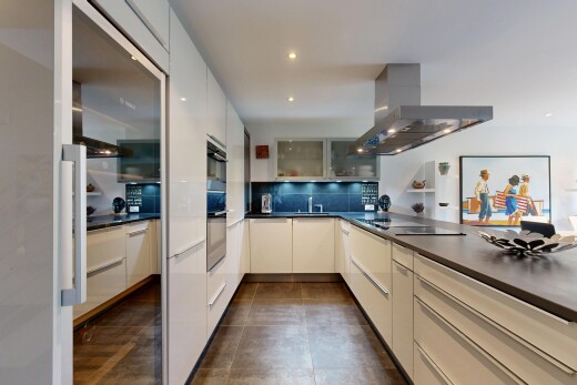küche mit dunstabzugshaube, arbeitsplatten, dark countertops, dark floor, und schränke mit glastüren