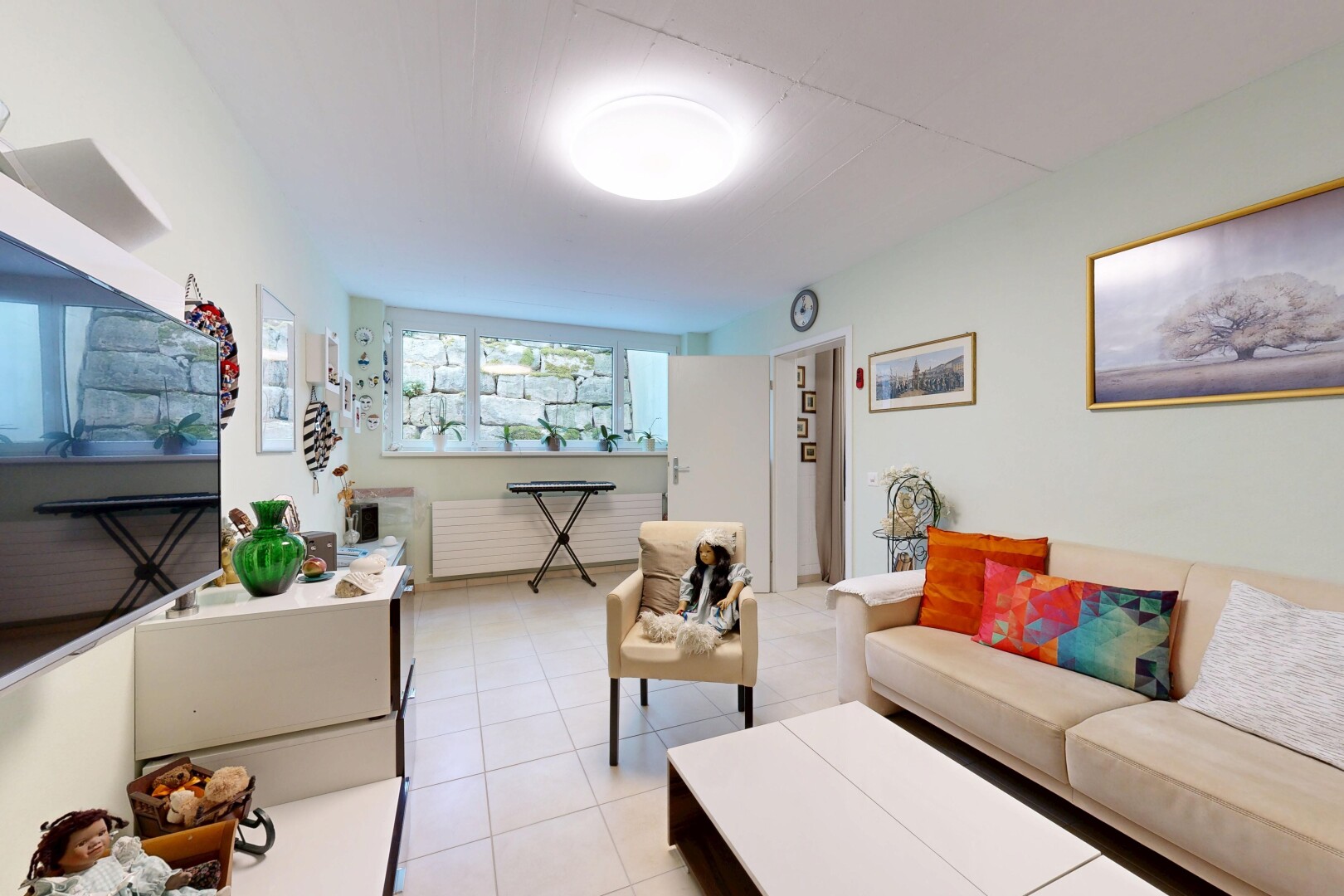 wohnzimmer mit fernseher, drywall, gipskartonwand, inside property, und tile floor
