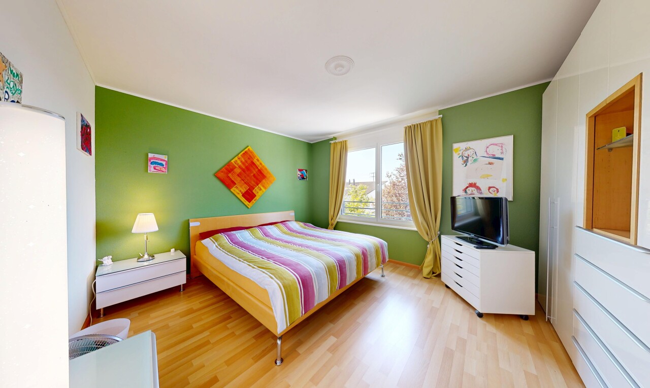 zimmer / schlafzimmer mit wood finish floor, holzfußboden, fernseher, drywall, und gipskartonwand