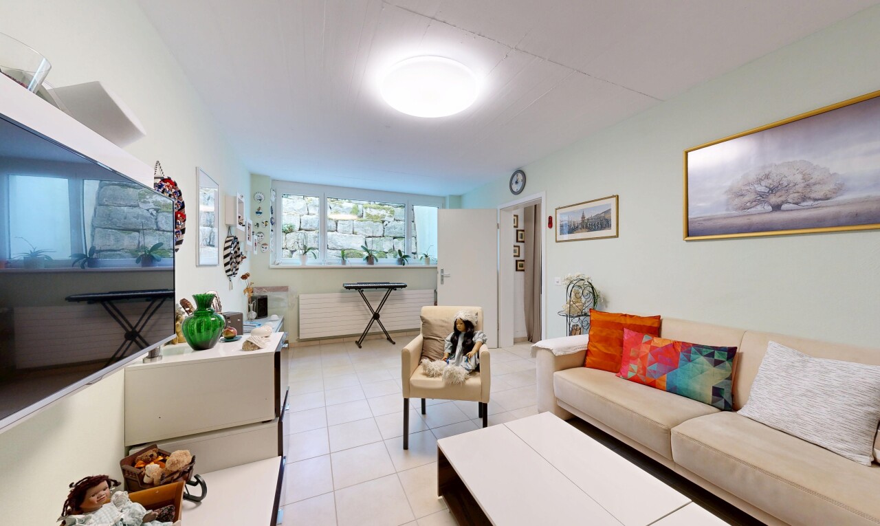 wohnzimmer mit fernseher, drywall, gipskartonwand, inside property, und tile floor