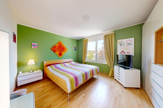 zimmer / schlafzimmer mit wood finish floor, holzfußboden, fernseher, drywall, und gipskartonwand