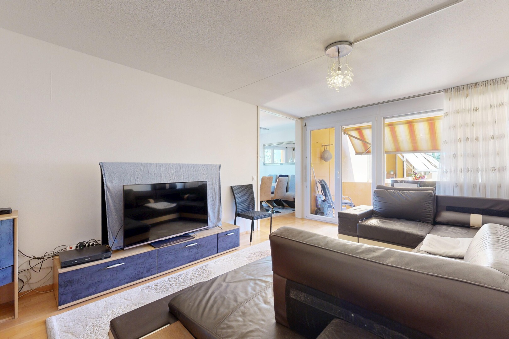 wohnzimmer mit gipskartonwand, drywall, fernseher, holzfußboden, und wood finish floor