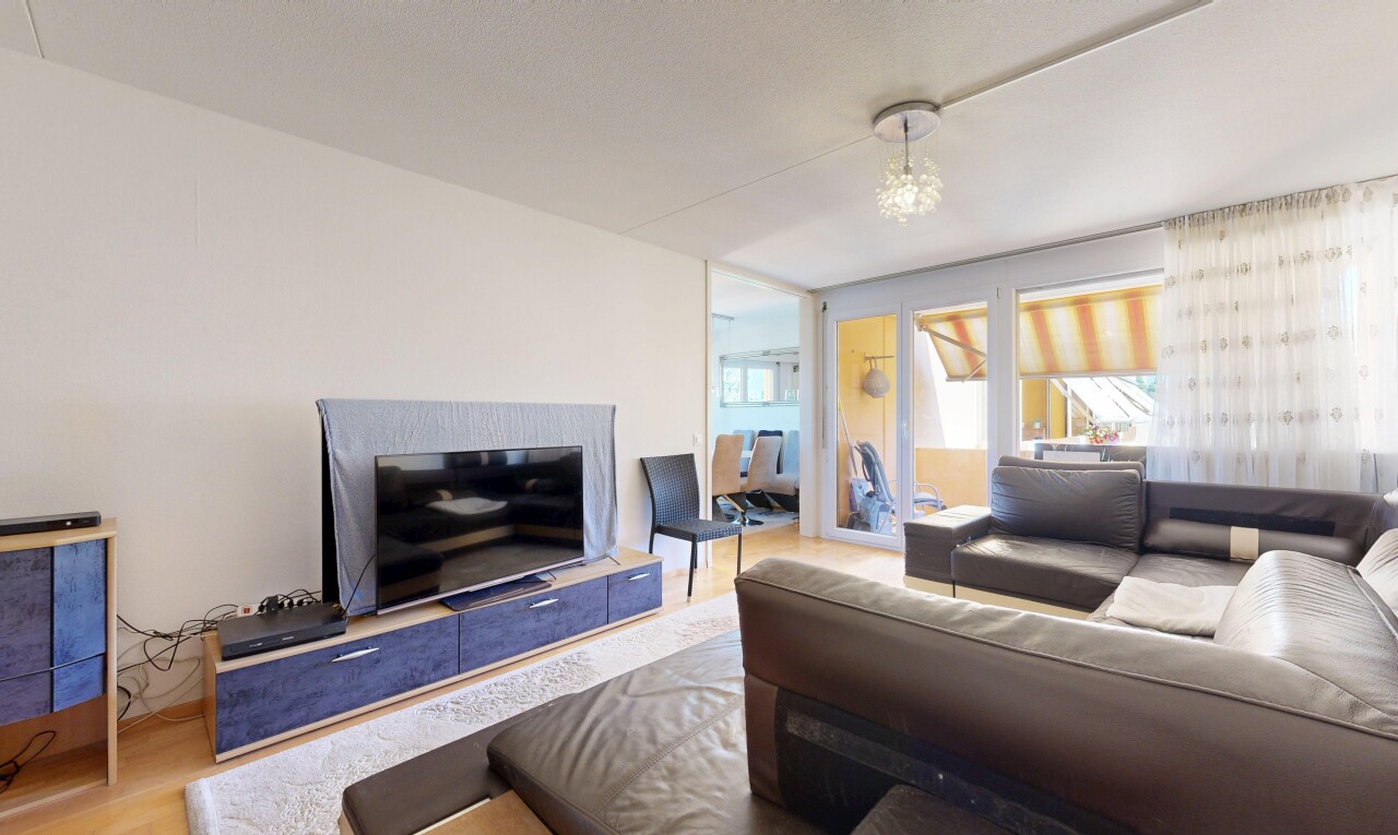 wohnzimmer mit gipskartonwand, drywall, fernseher, holzfußboden, und wood finish floor
