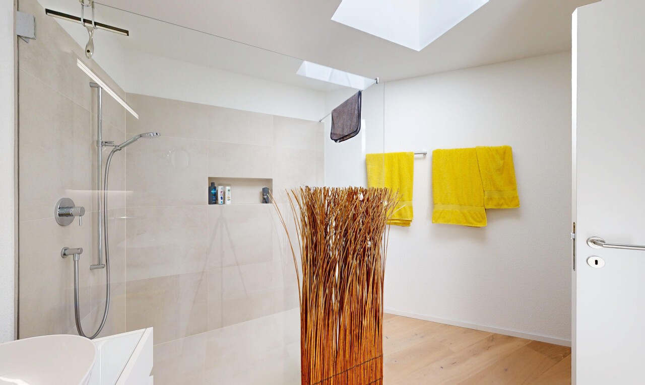 bathroom featuring walk in shower, a skylight, and light wood finished floors